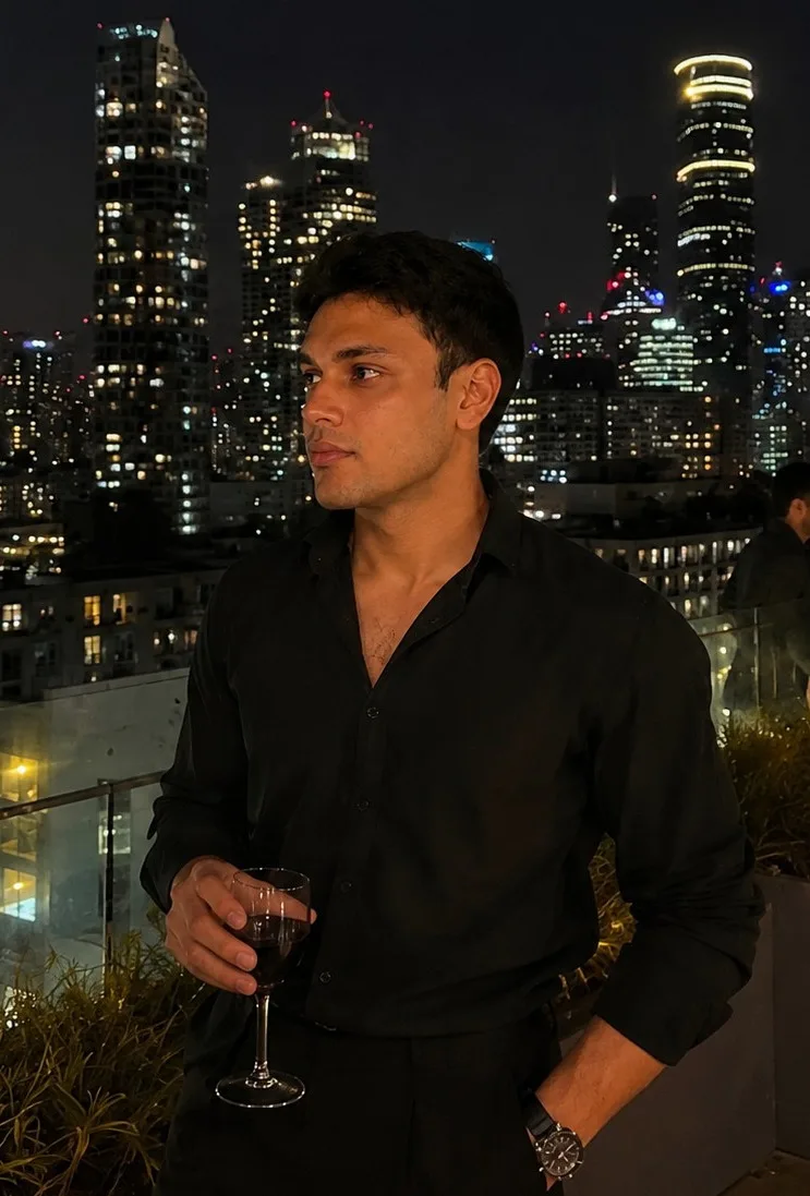 Abhinav Thakur on a rooftop in Melbourne at night, city skyline behind him